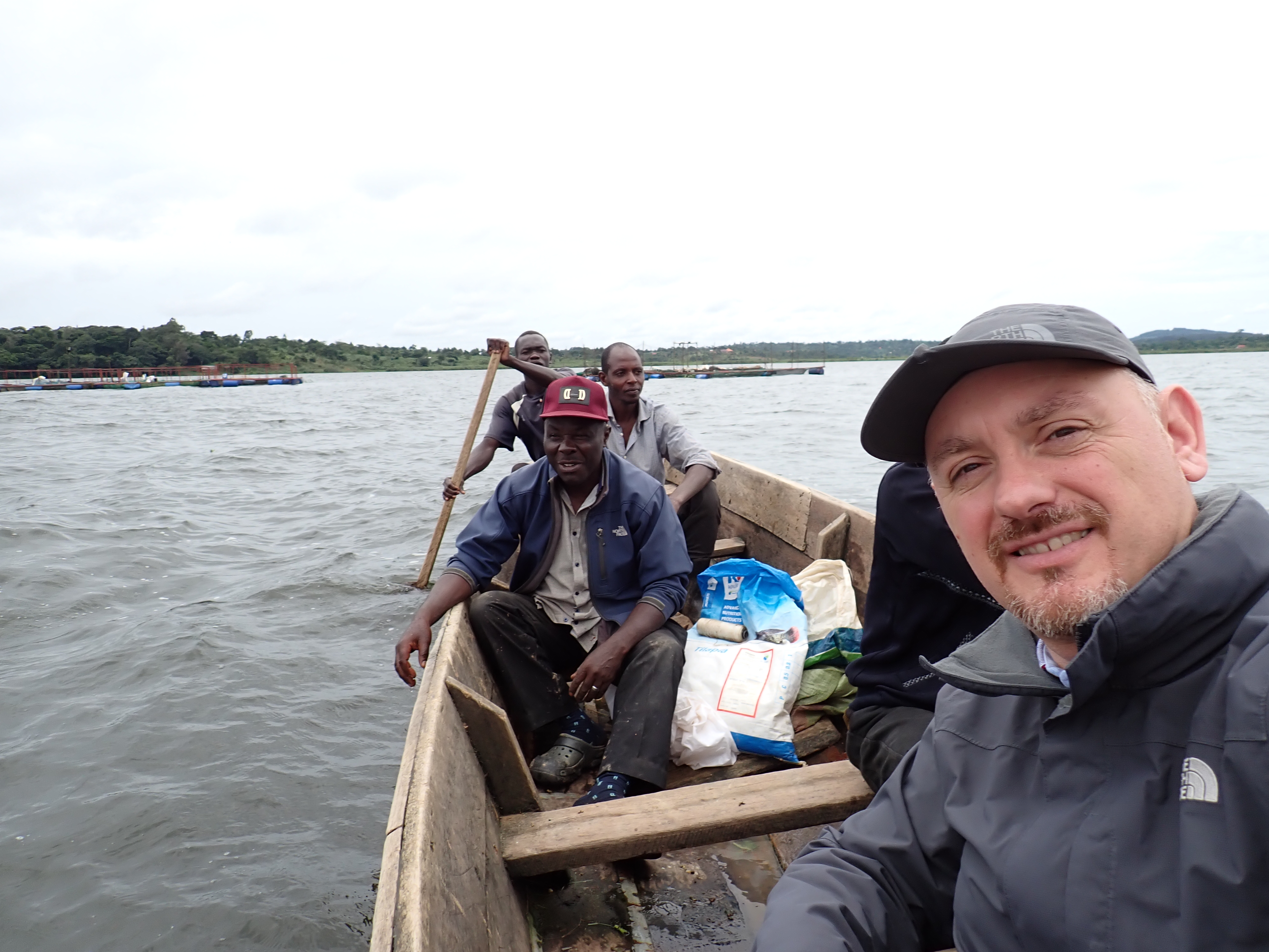 Dr. Gorgoglione (front right) reaching a fish case by boat with local tilapia farmers on Lake Victoria.