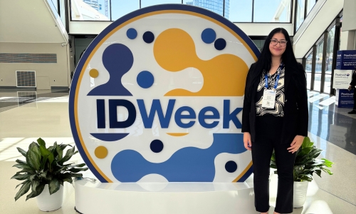 Olivia Slewa standing next to an IDWeek sculpture at the 2025 IDWeek conference