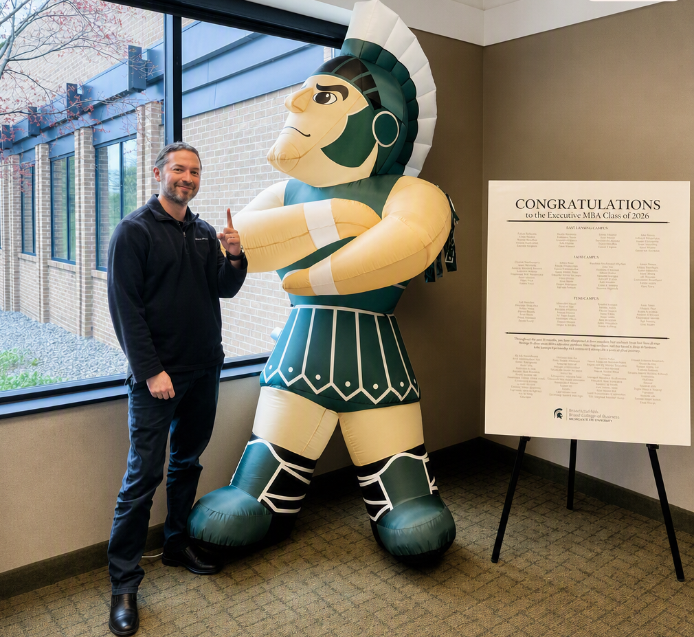 Adrian Oliveras standing next to a blow-up Sparty inflatable