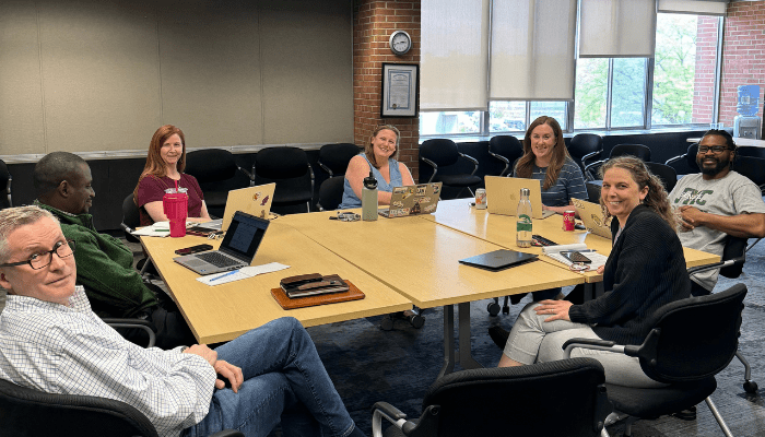 The James Madison College academic advising team meeting in the James Madison College library.