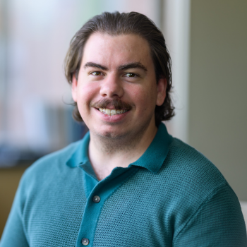 Michael Downs, smiling and wearing a green collared shirt.