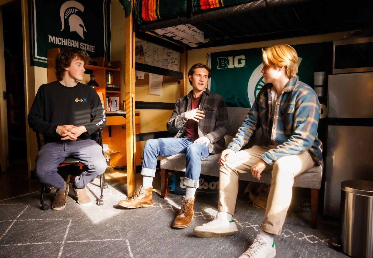 James Madison College students socializing and studying together inside a Case Hall dorm room residence hall.