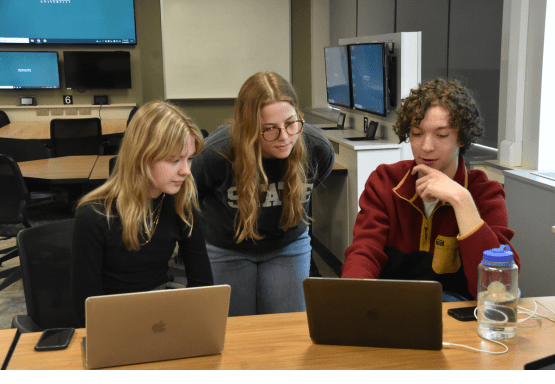 This image shows a group of James Madison College students working on research for the Human Rights Data Science Lab.