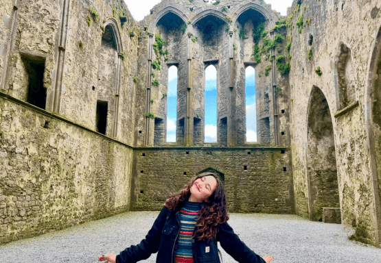 This photo shows Amaya Aten (CCP '25) standing in front of a historic building in Ireland.