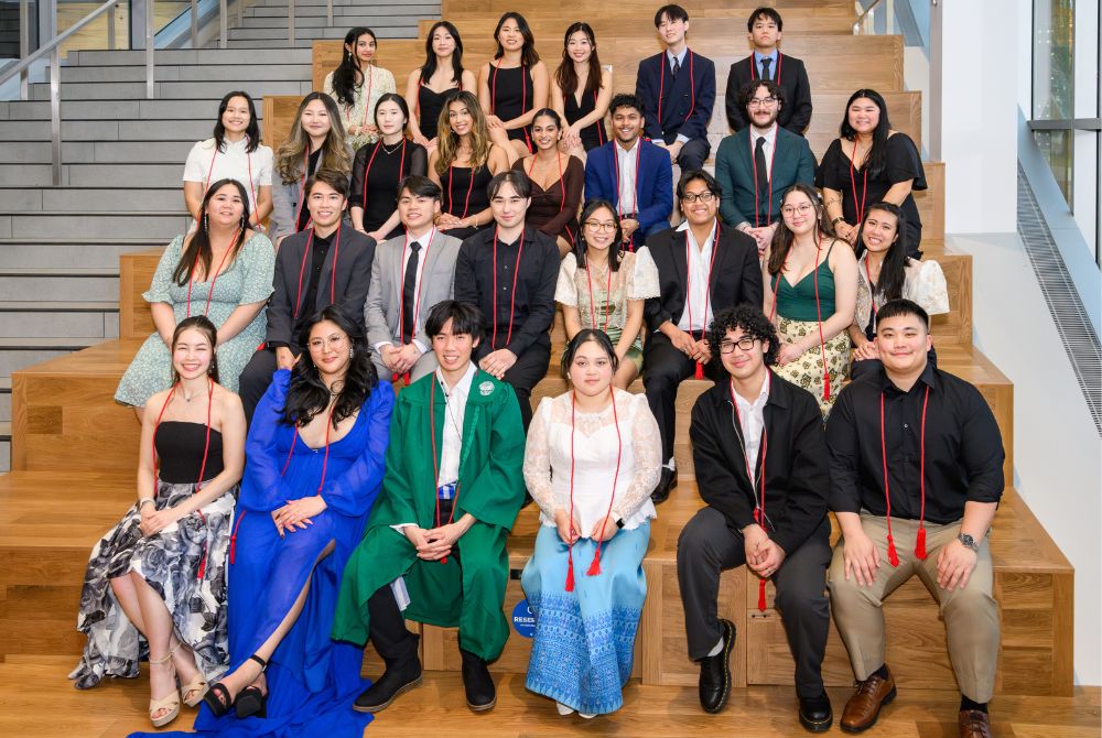 Members of MSU APASO photographed as a large group, sitting on rows on a set of wide stairs.