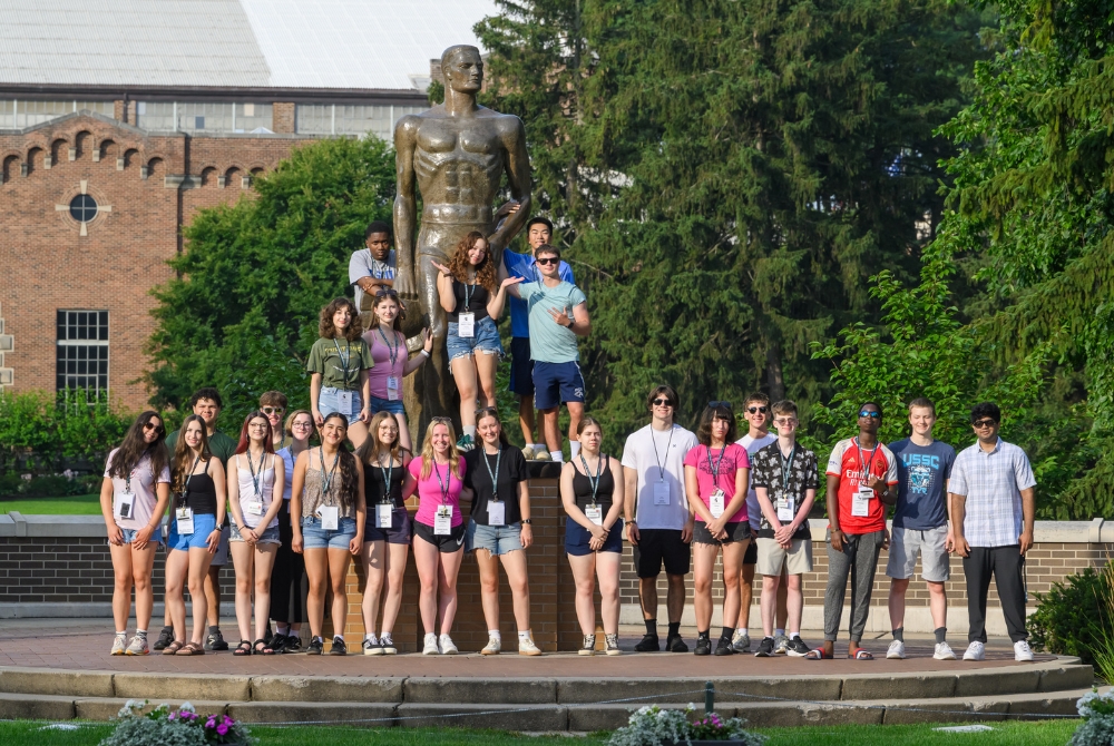 A large group of students posing with the MSU Sparty statue during the JMC Academy for Civic Education.