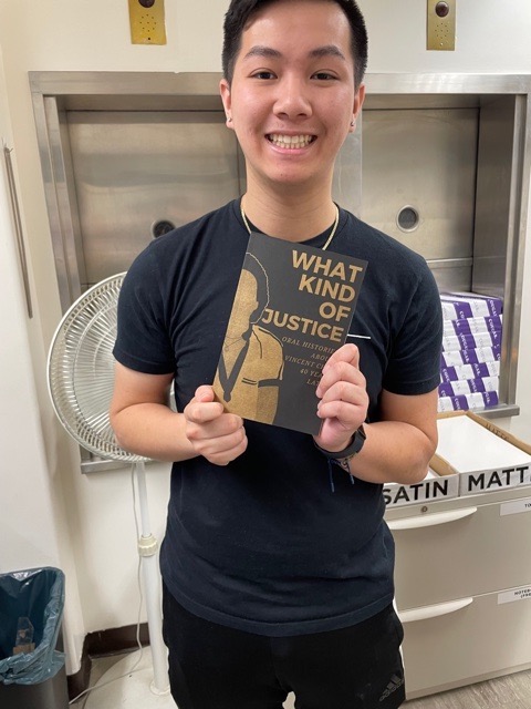 David Tran holding up a copy of a book