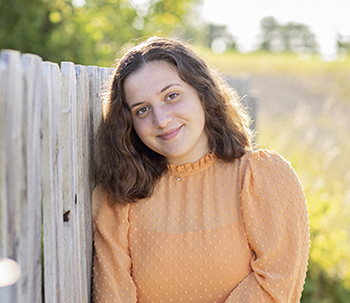 woman leaning against a fence