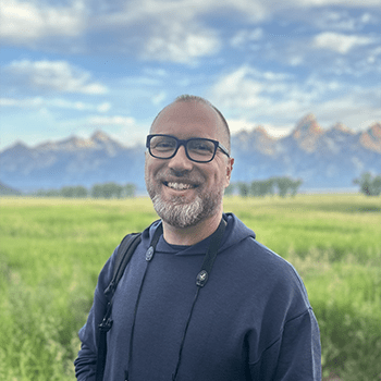 Photo of Daniel Ahlquist in front of mountains. 