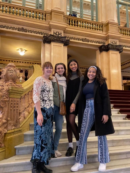 Several women standing on steps outside of building