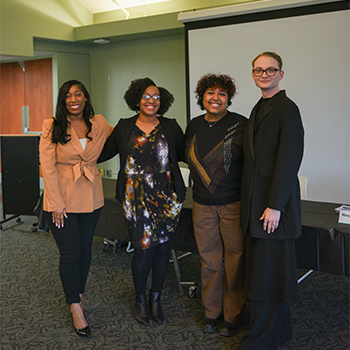 four people arm-in-arm pose for a photo