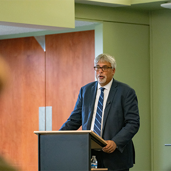 Sam Singh speaks at podium