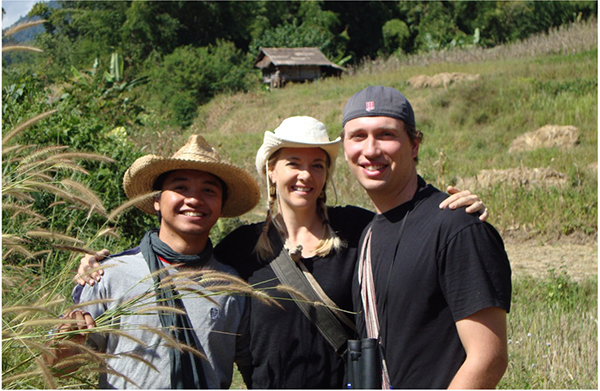 three people standing together in a field