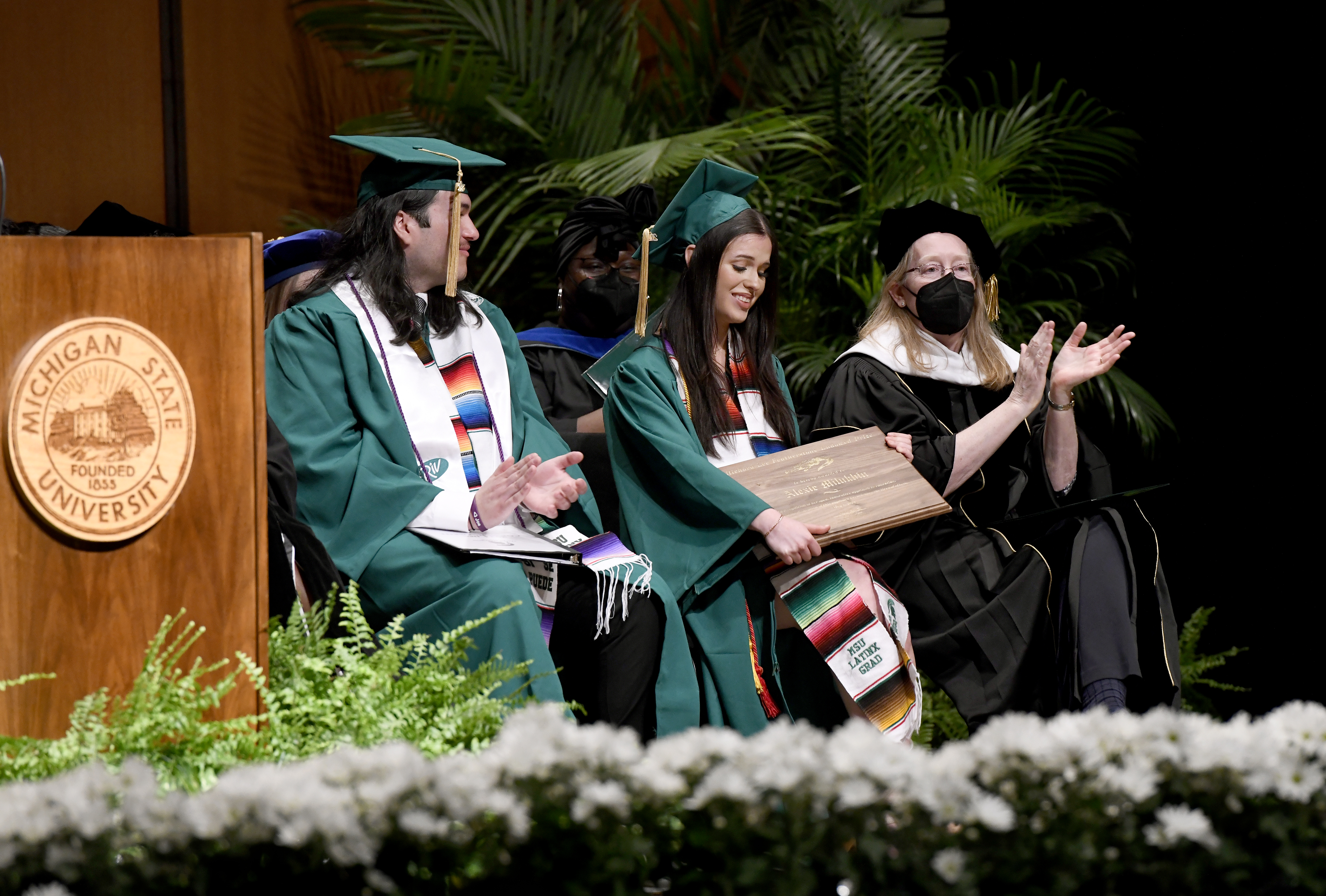 Two students and a faculty member on stage