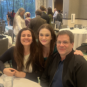 student with parents at table