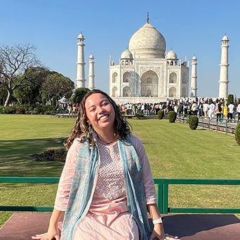 Sydney sits on a bench in front of the Taj Mahal