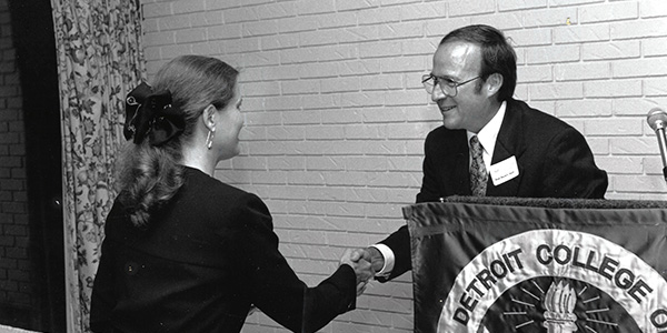 This photo, taken September 28, 1995, shows Favre in his role as interim dean unveiling of the plans for the new law school at MSU, shaking hands with then Associate Dean Brenda Quick.