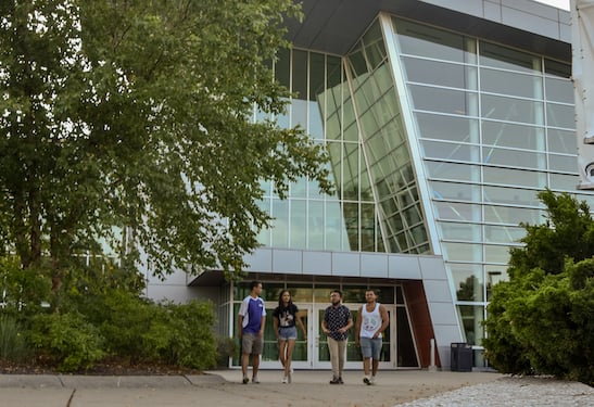 A group of students walks outside Brody Hall. 