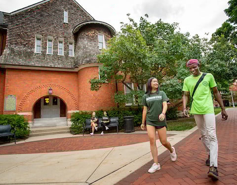 Two students walk in front of the Honors College at Michigan State University