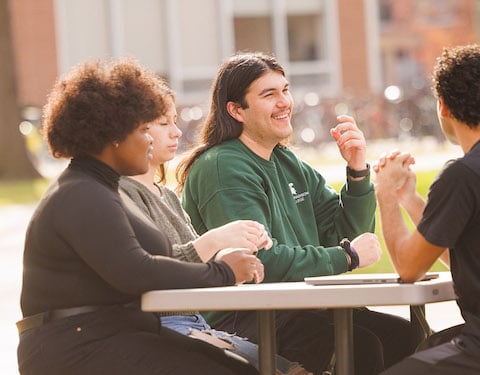 Students sitting at a table outside of Case Hall