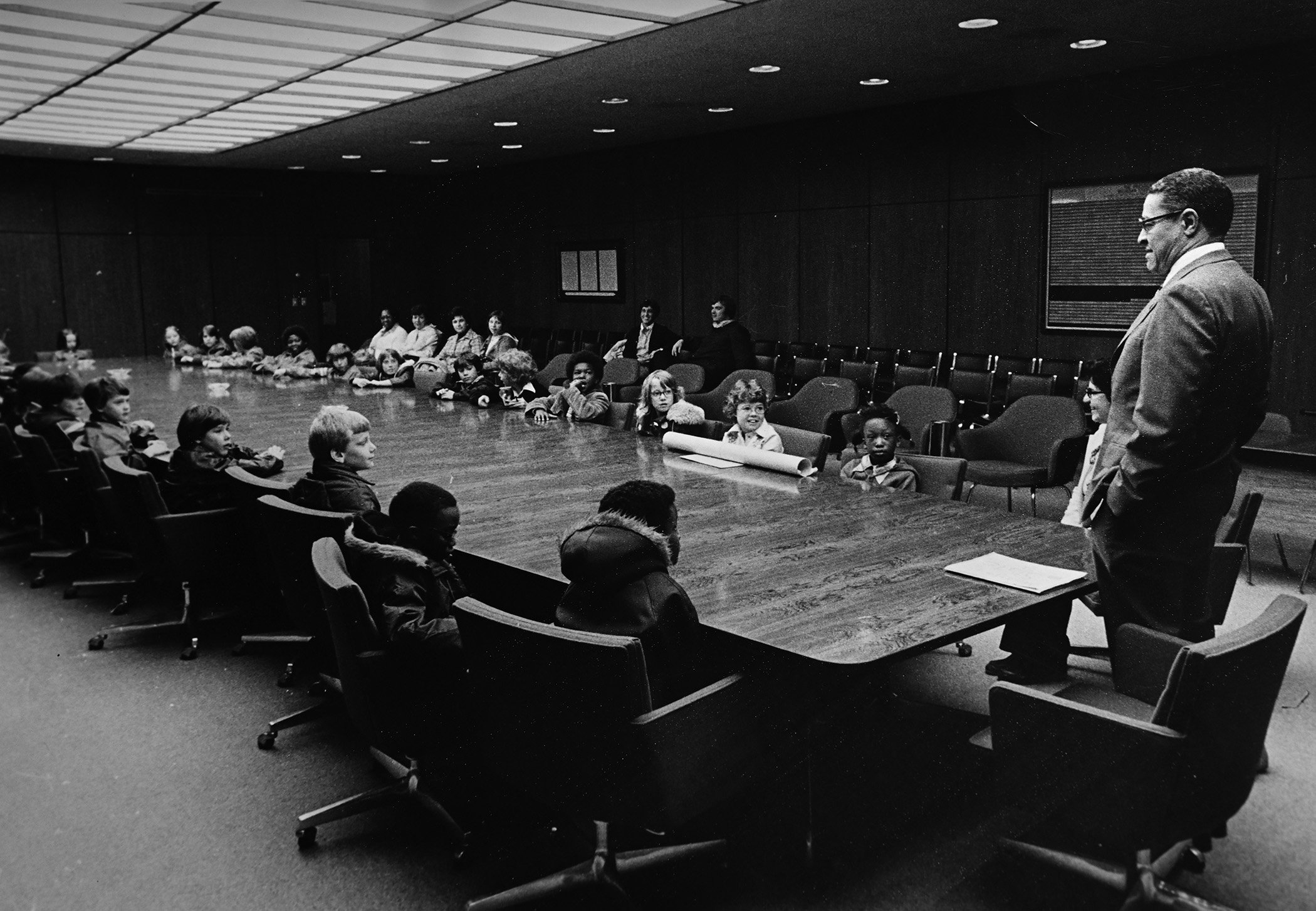 Wharton and children at board room table