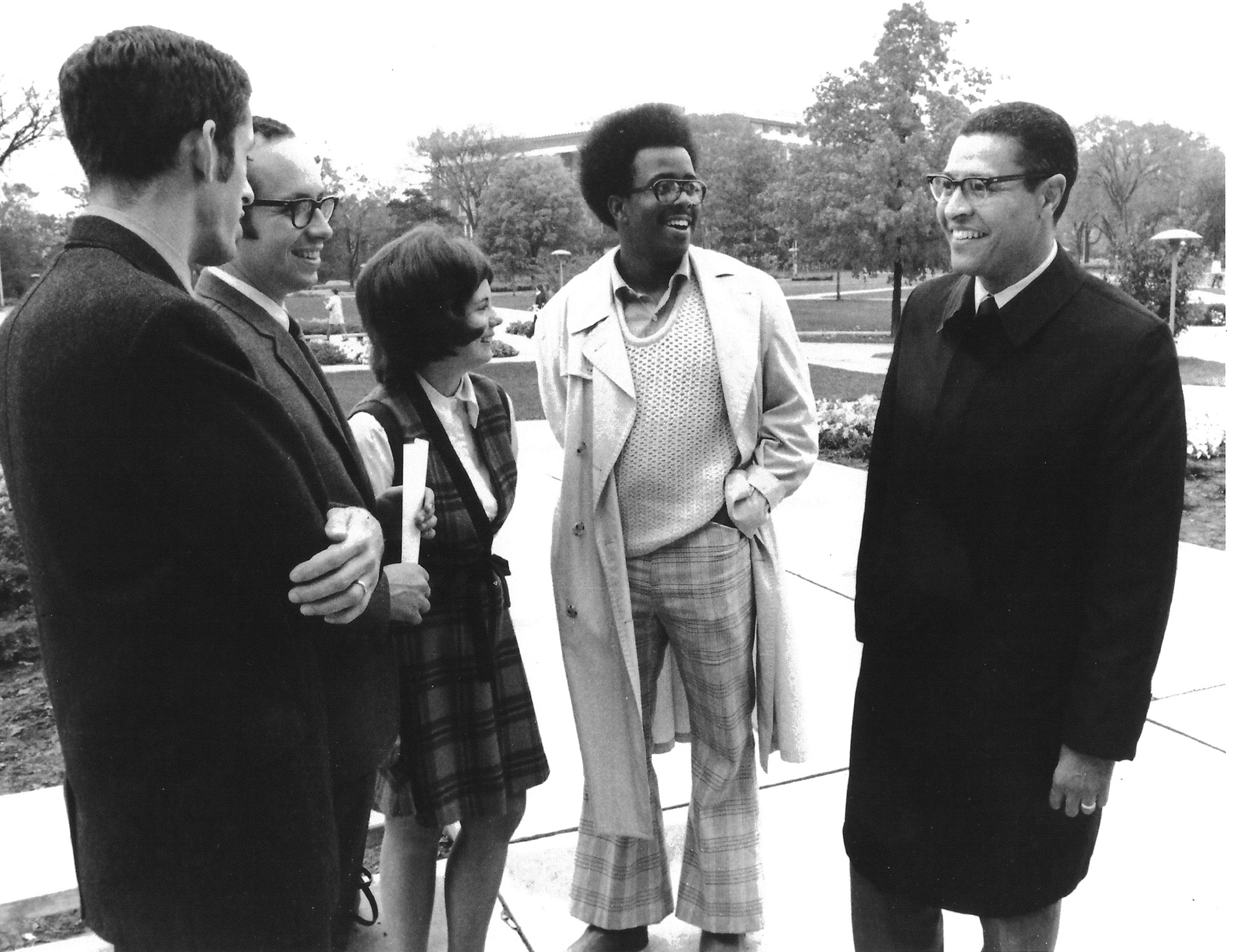 Black and white photograph of four people talking