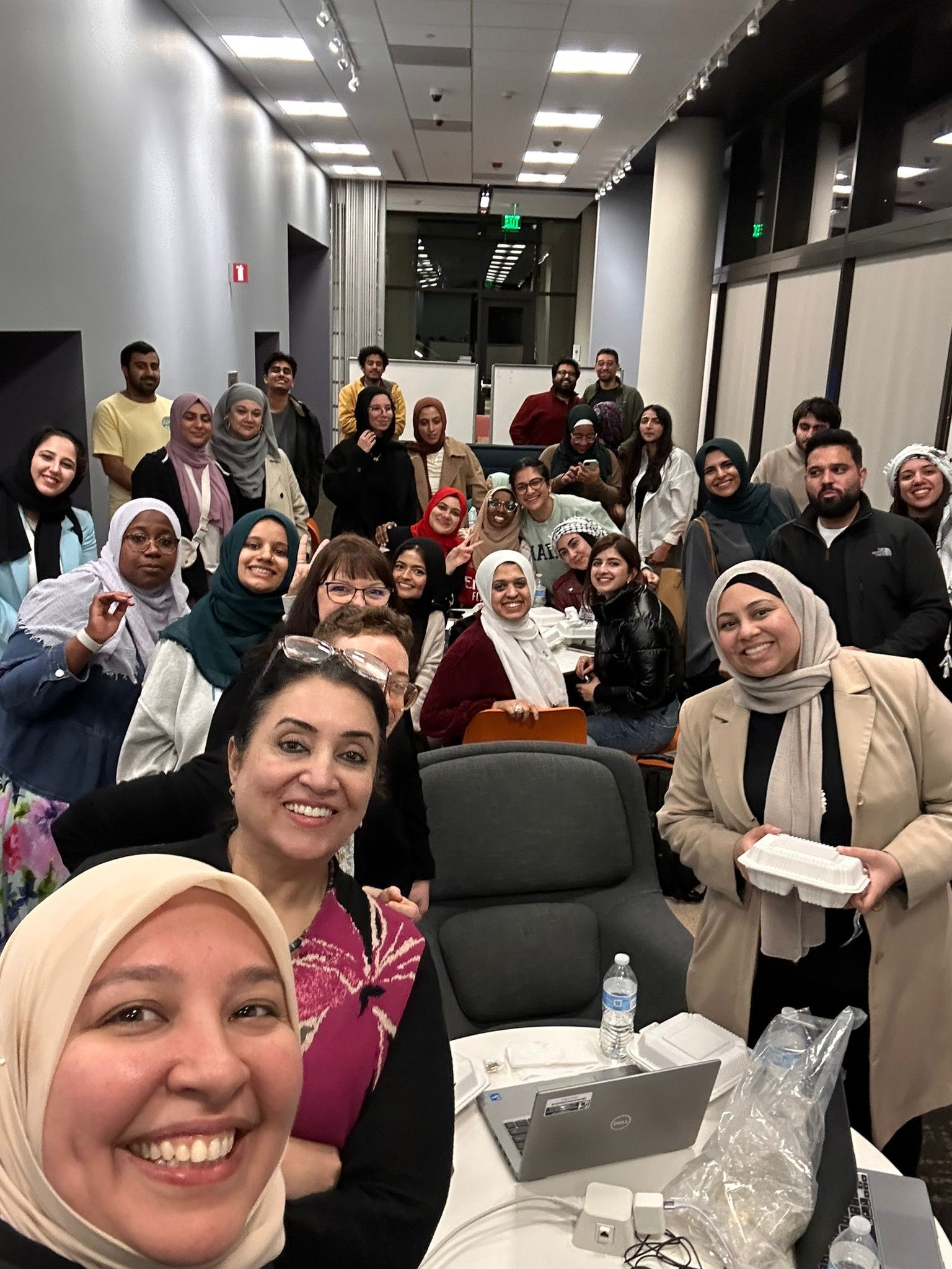 A group photo featuring Dr. Farha Abbasi and a large group of volunteers, getting ready for the 16th Annual Muslim Mental Health Conference.