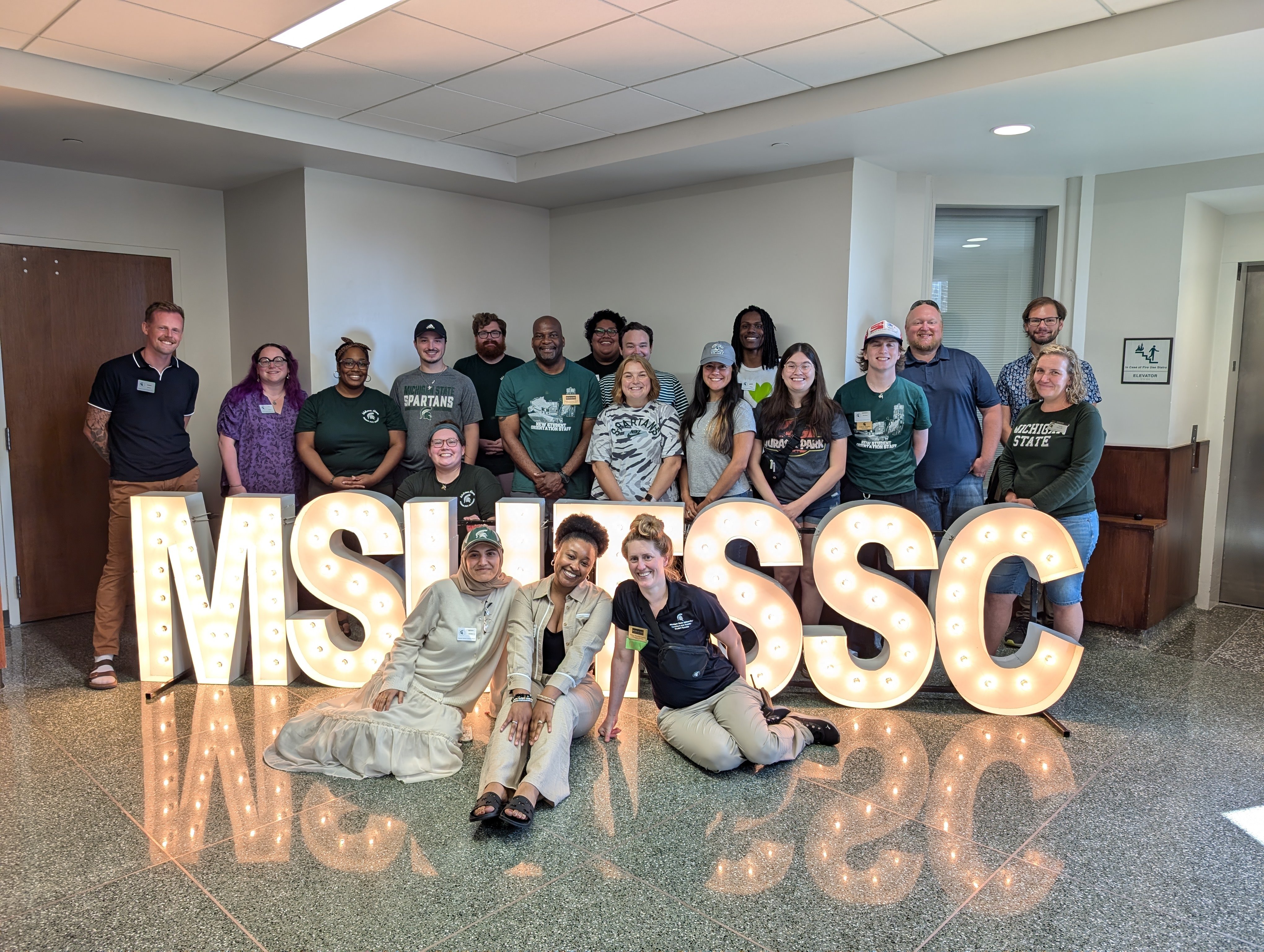 Members and supporters of the Transfer Student Success Center posed in front of LED letters for the Transfer Student Resource Fair in 2024.