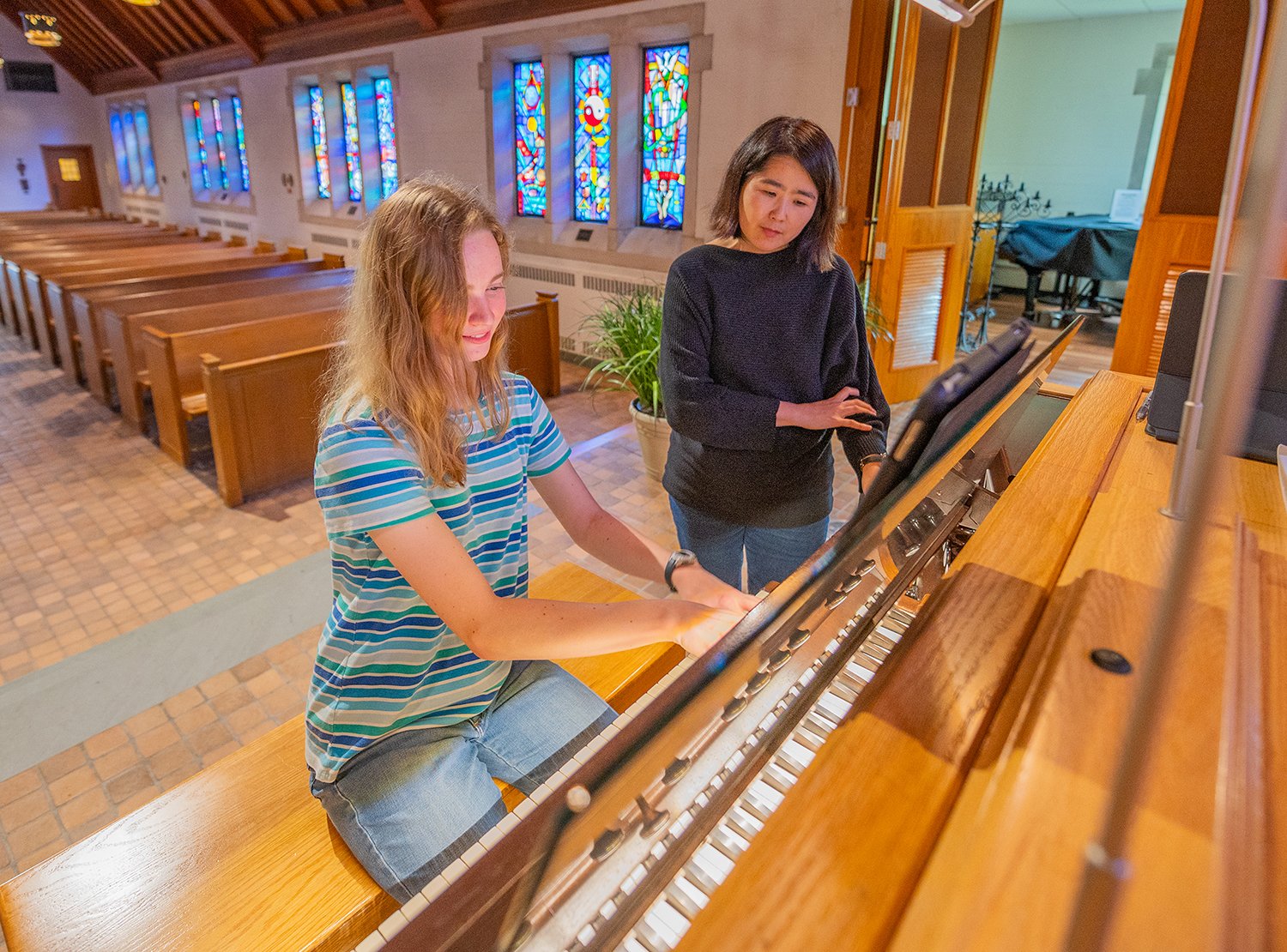 A faculty member and student learn on the piano.