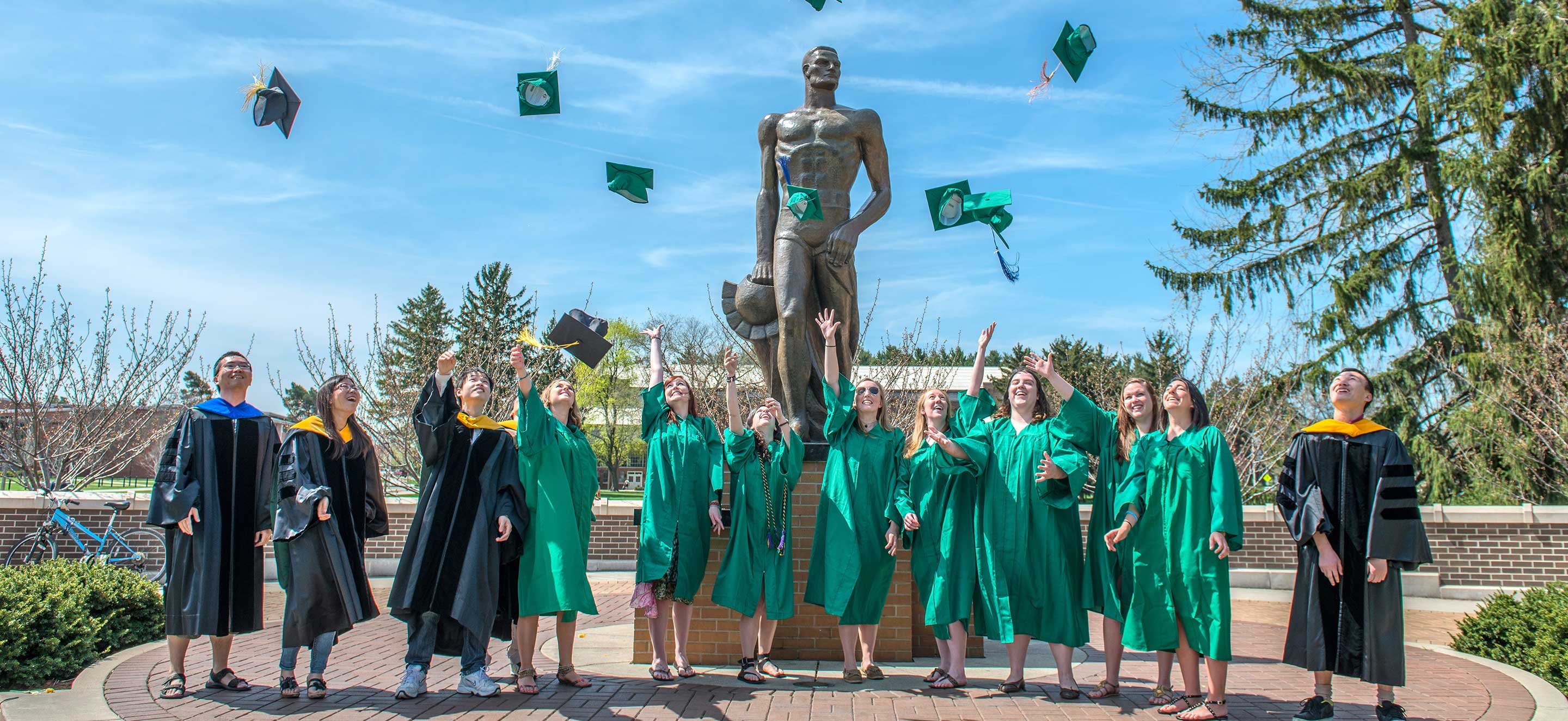 graduates in front of sparty statue 