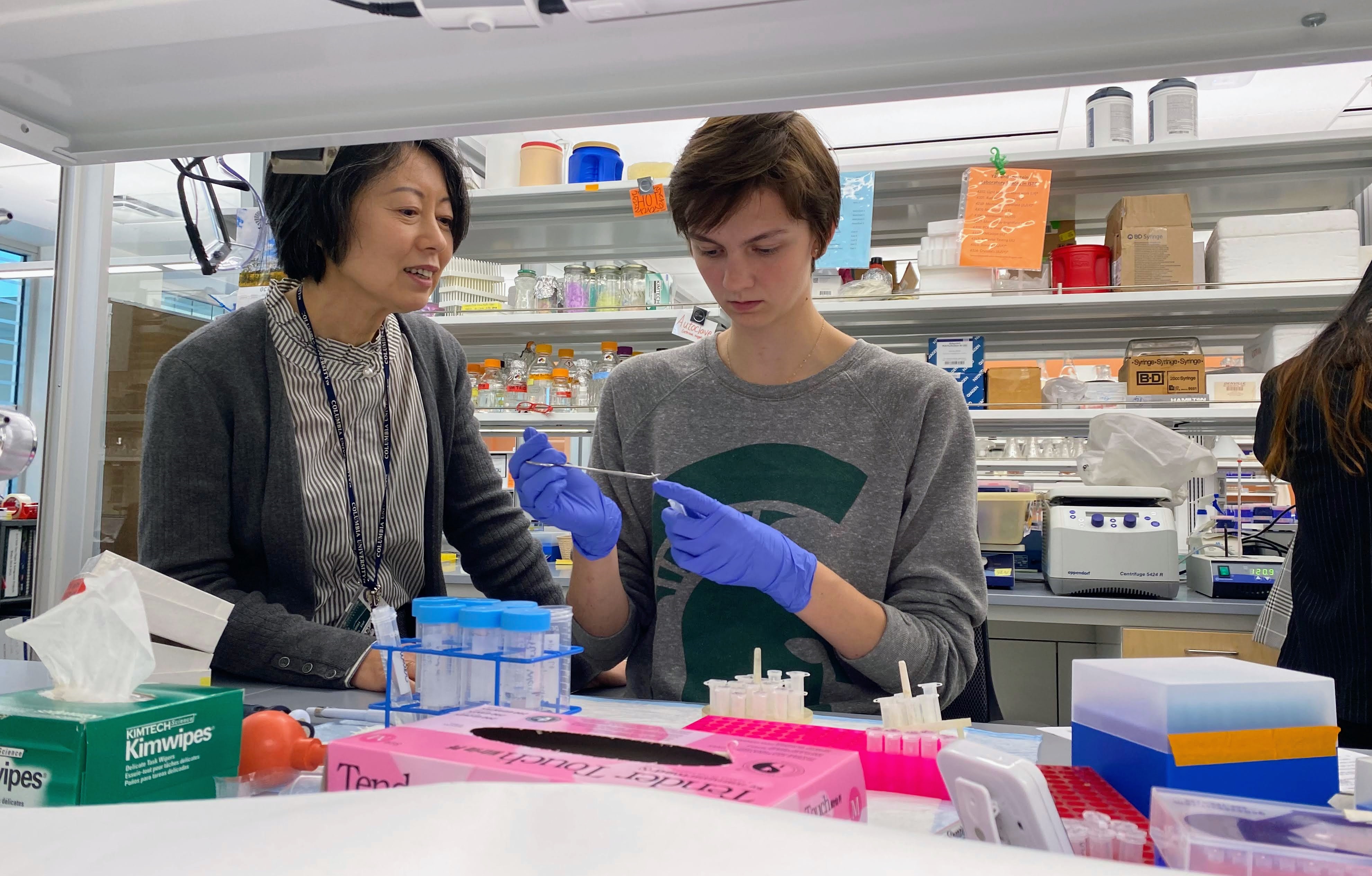 Dr. Yan works with a student in her lab.