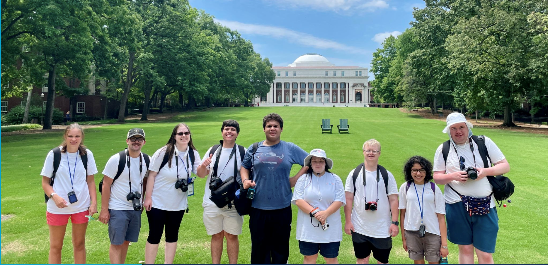 A group of AbleVoices members on a photoshoot. Outside on a sunny day.