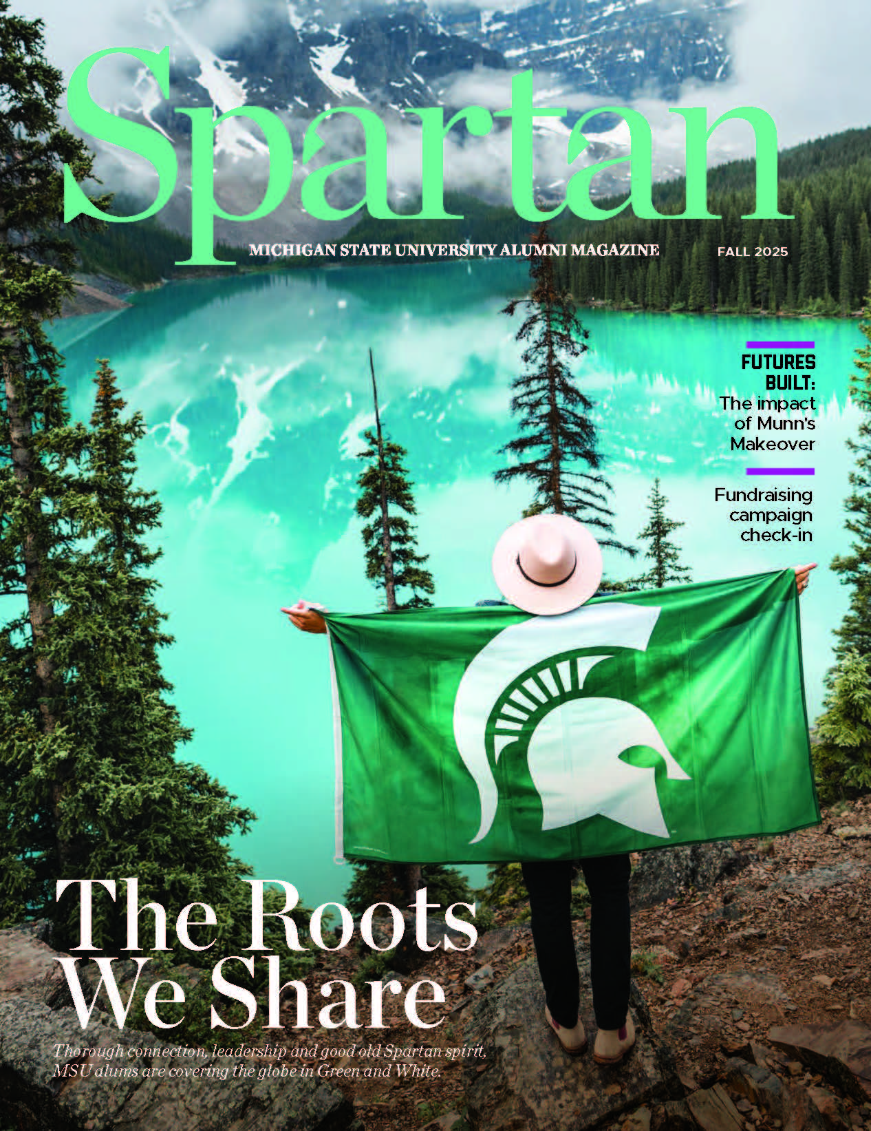 a person holding a Spartan flag in front of a mountain lake.