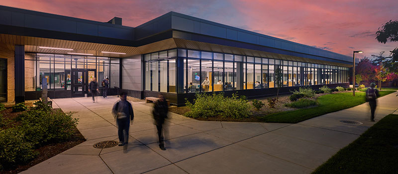 the facade of the MSU Packaging Building at night, with windows lit up from inside to show some of the new study areas