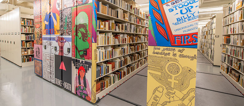 a view of the brightly lit and colorfully decorated shelving units inside MSU's new Special Collections facility within the MSU Main Library