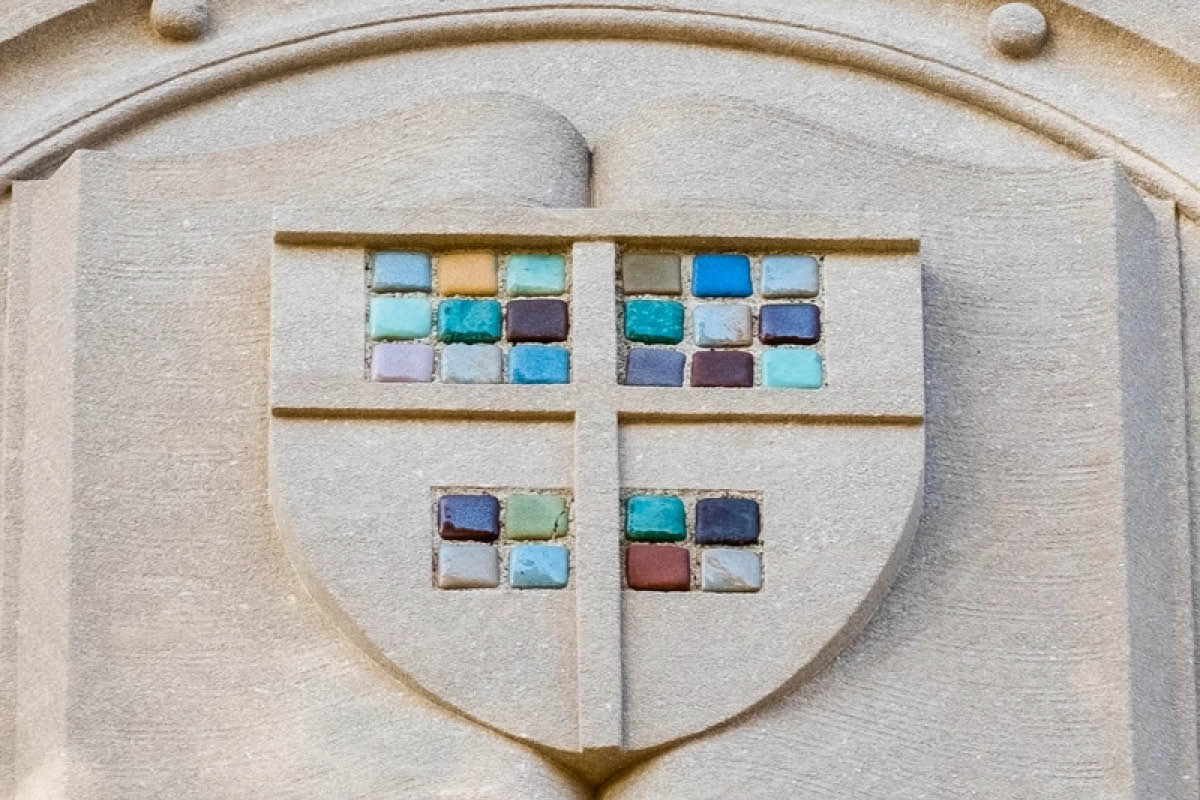 A stone shield with Pewabic tile on the outside edifice of Kedzie Hall.