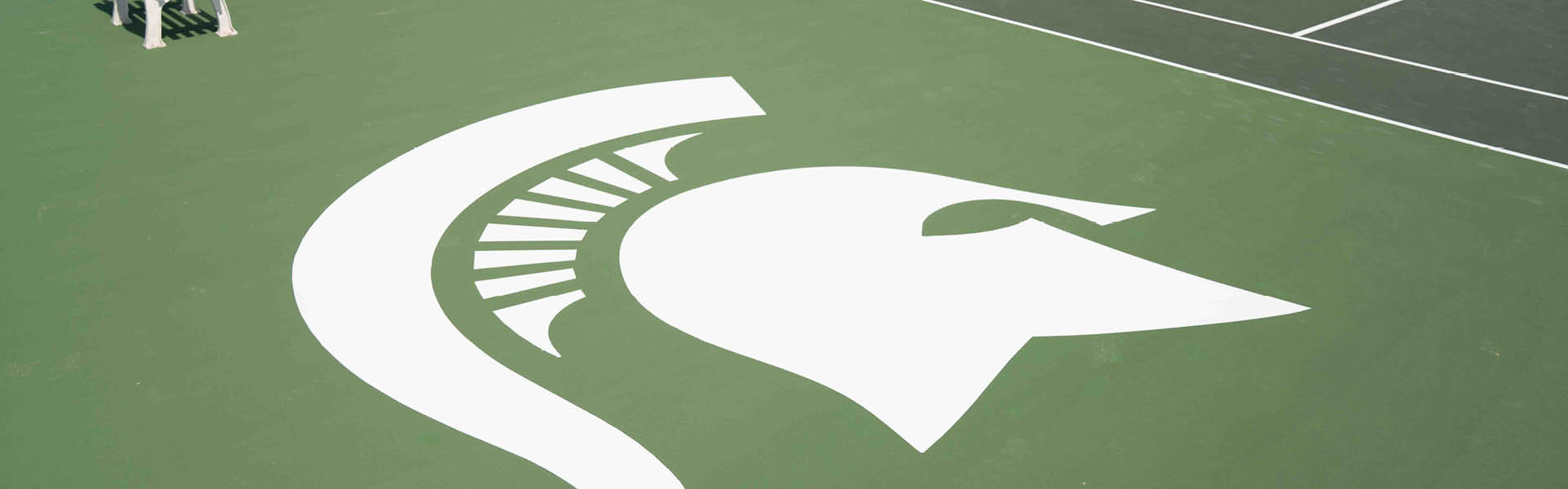 Close up of the MSU Spartan head logo on the new men's and women's tennis courts.