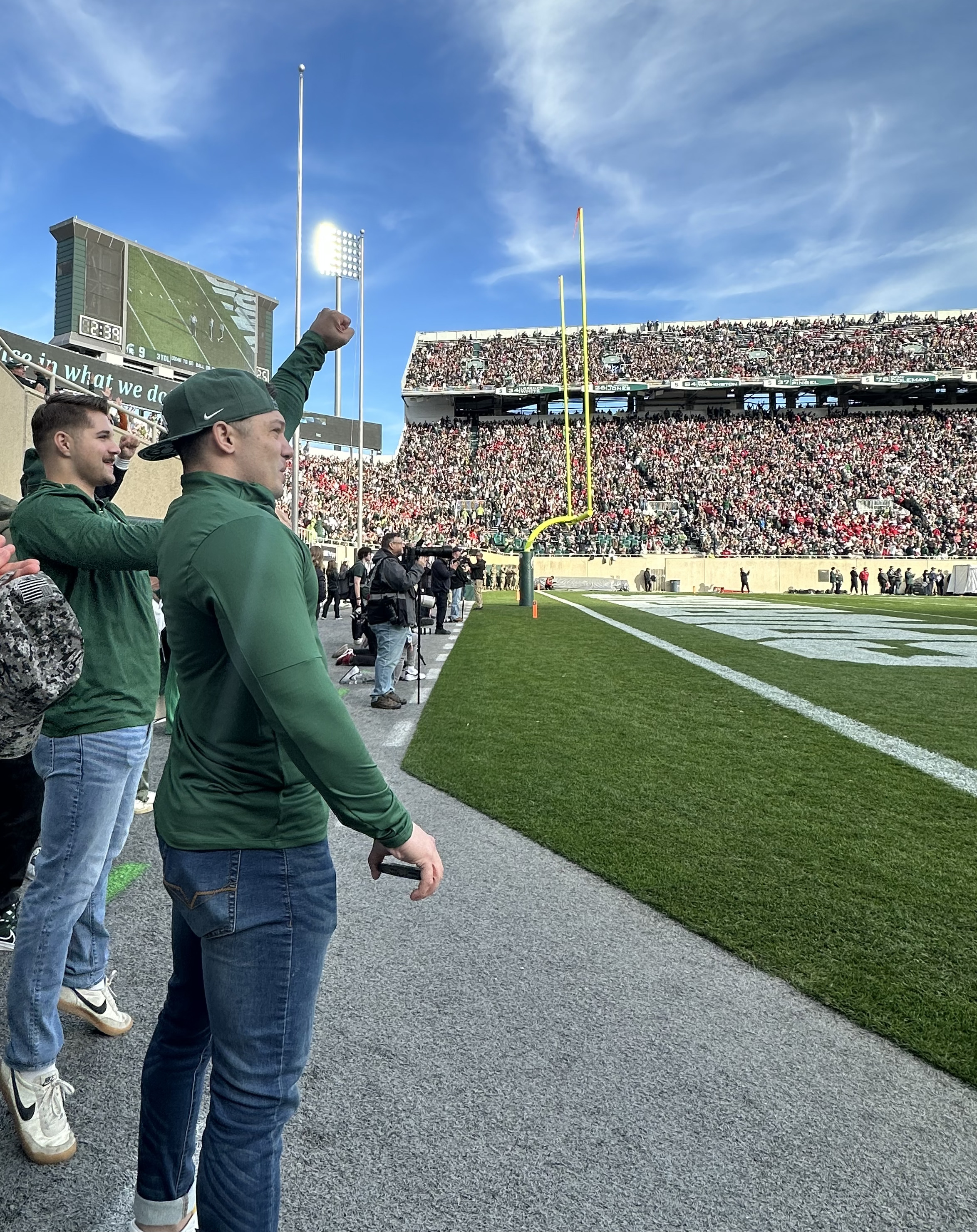 MSU student veteran Kyle Hiner cheers on the Spartans at a university football game.