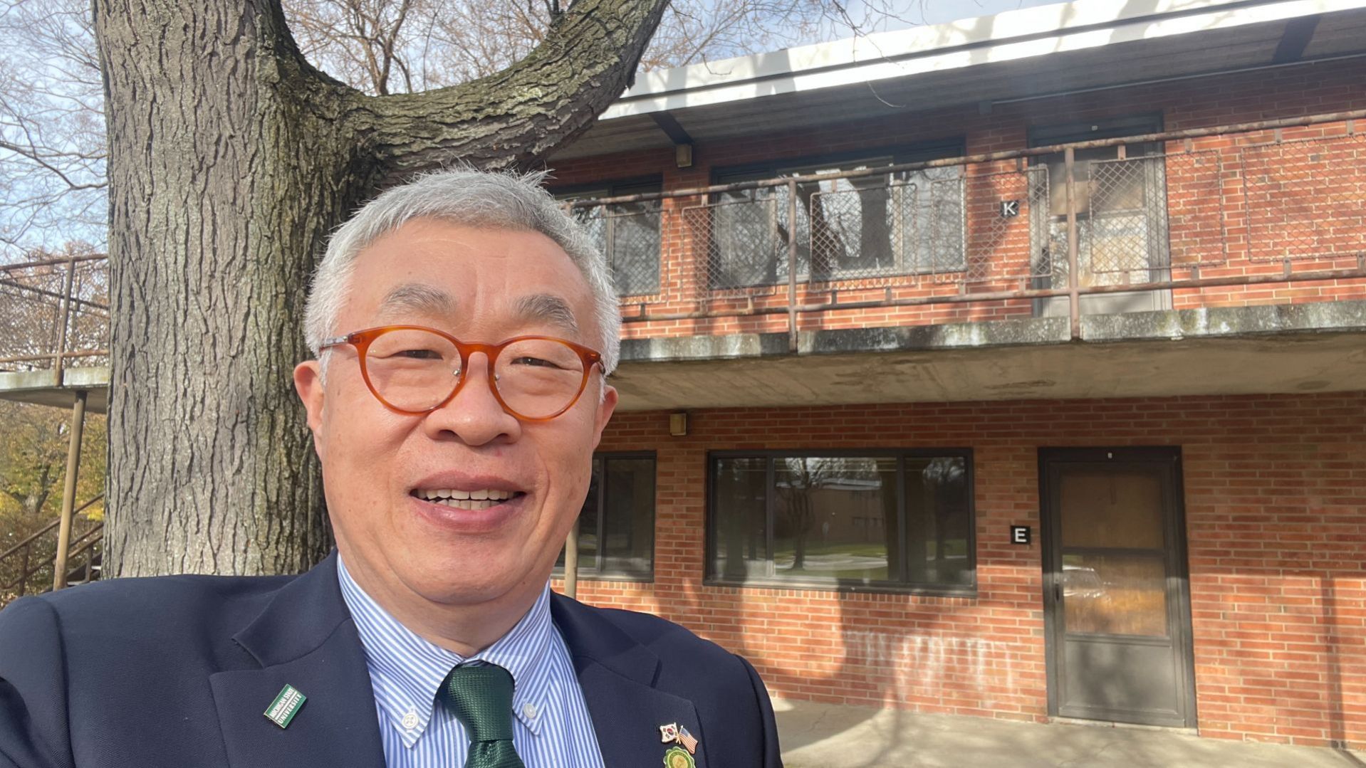 Myung stands outside his Spartan Village apartment during a visit to Michigan.