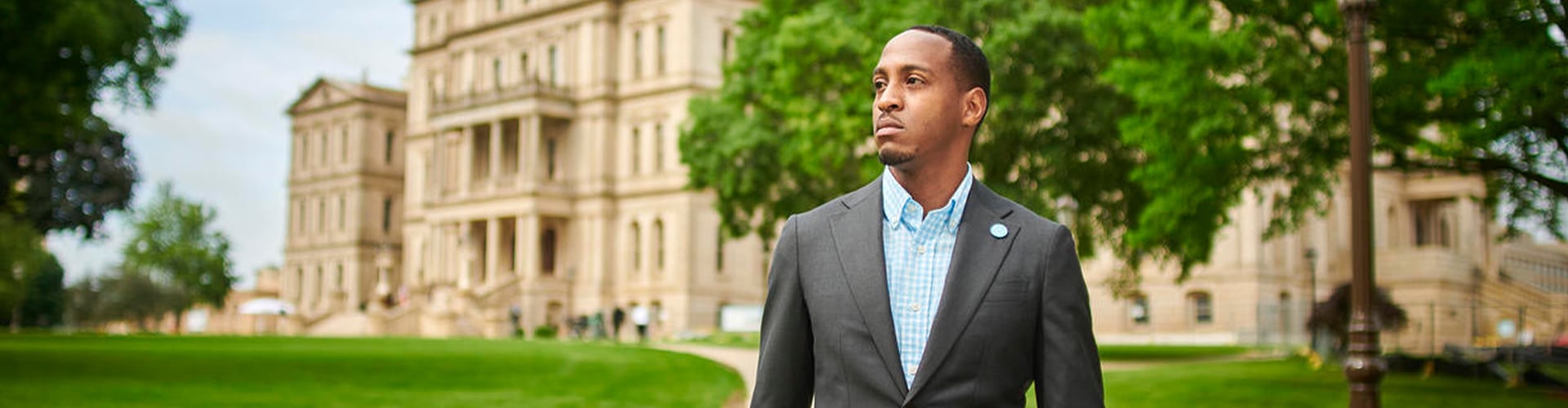 Jeremy Orr standing in front of the Capitol Building, wearing a suit, looking to the left.