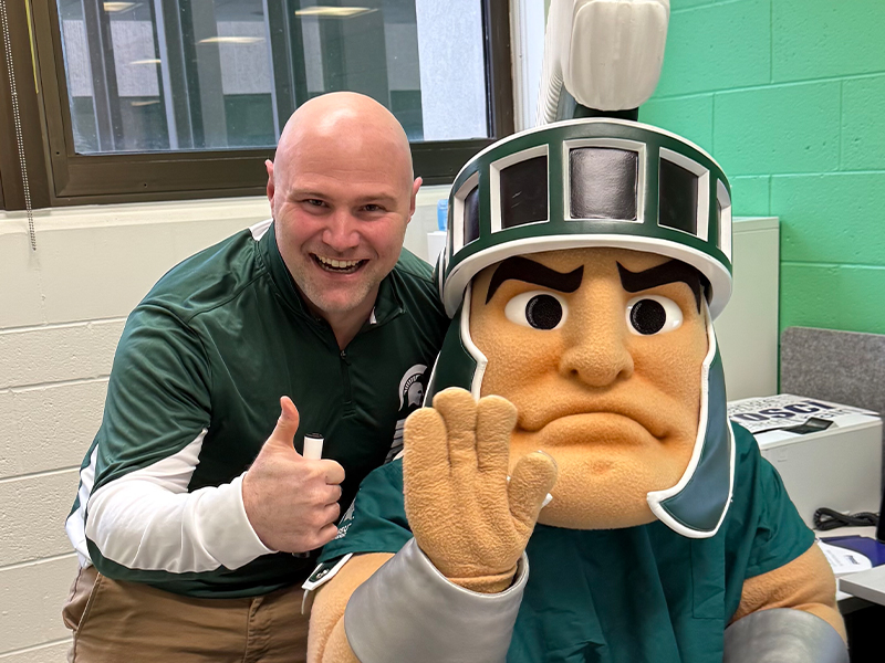 Lucas VanEtt, in a green Spartan polo, with Sparty