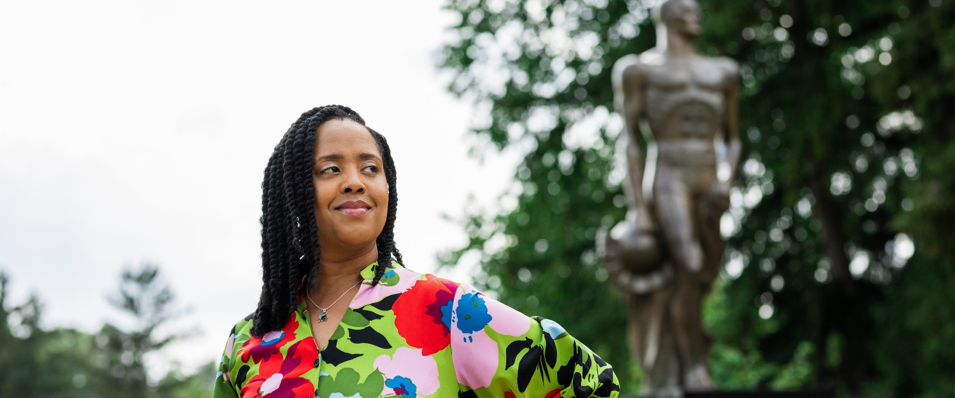 Essence standing in front of the Spartan Statue, looking over her right shoulder, grinning.