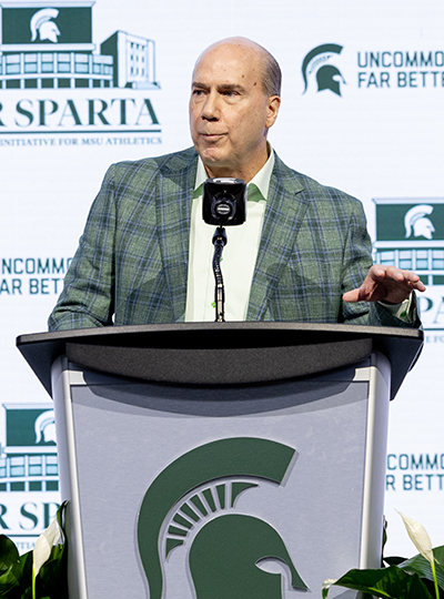 Greg Williams stands at a podium speaking