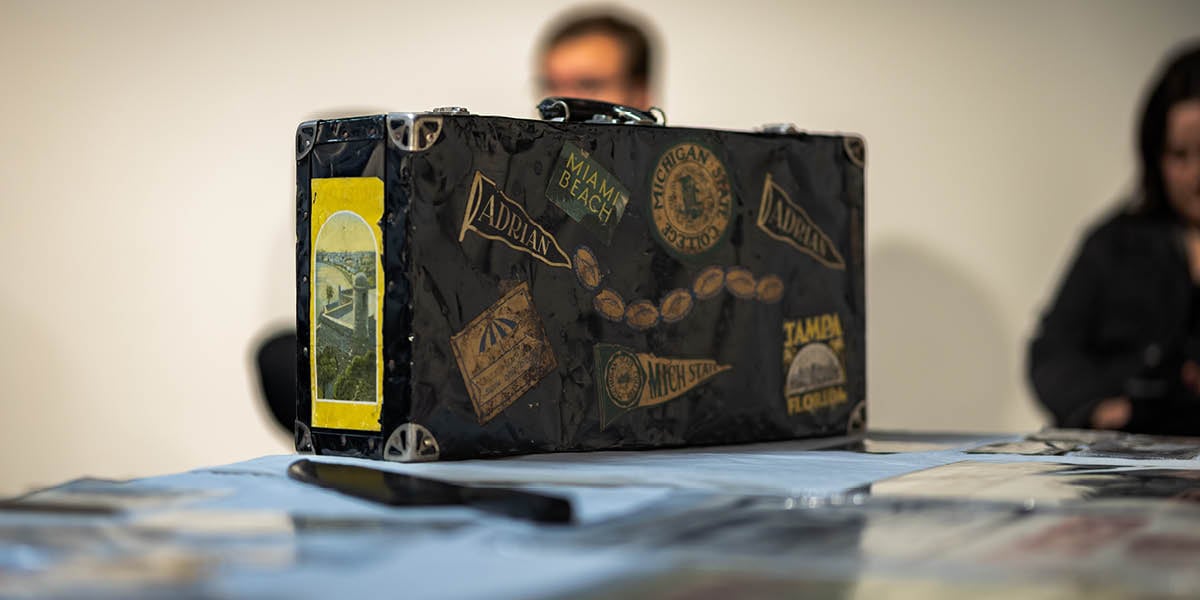 Photo of an old MSU instrument case covered in vintage stickers in the Immersive Lab at the MSU Museum.