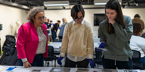 MSU Professor of Museum Studies Suzanne Fisher looks over Spartan artifacts with two members of her class.