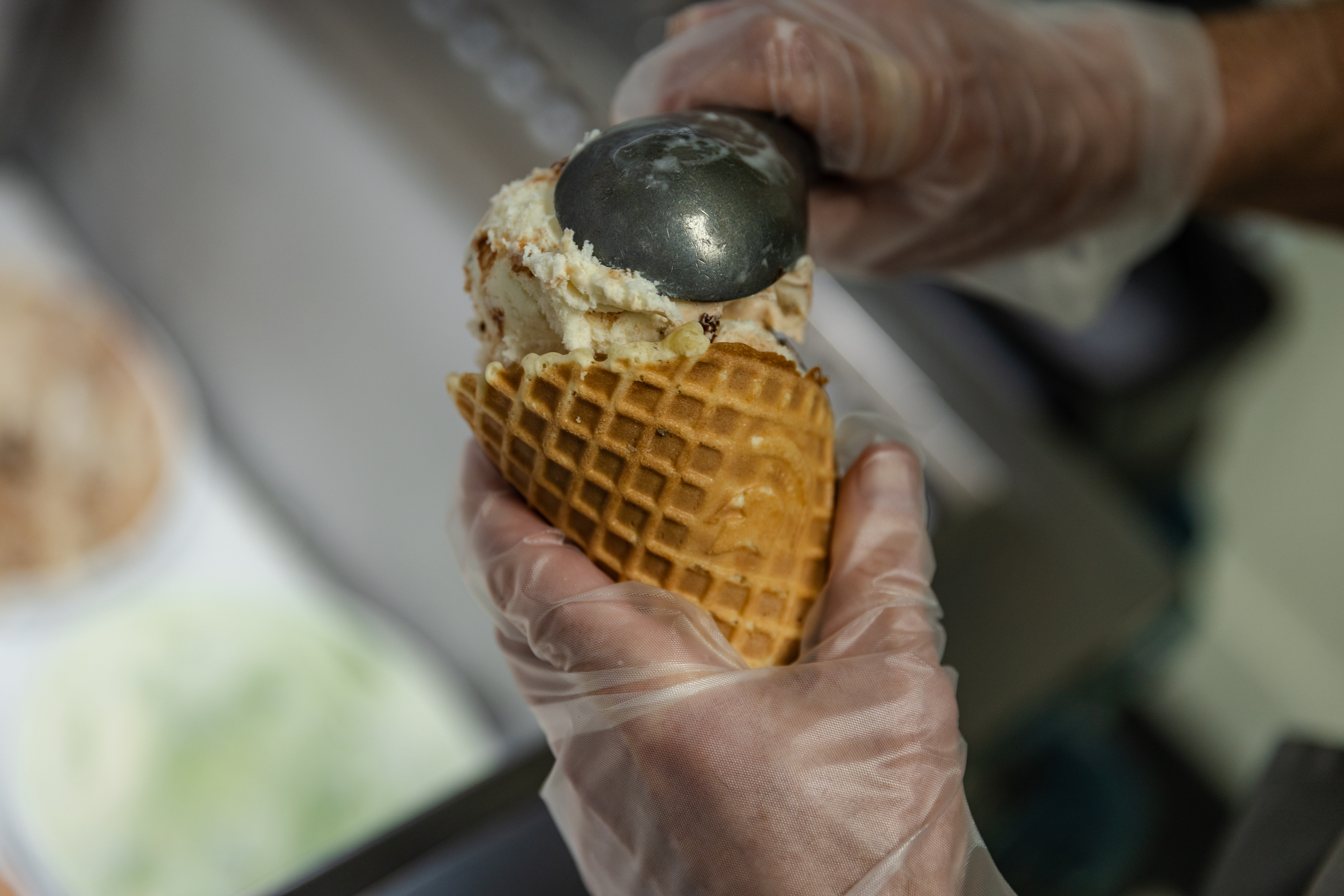 Far Better Swirl'd, a new Dairy Store flavor celebrating the campaign, Uncommon Will. Far Better World. being placed on a cone