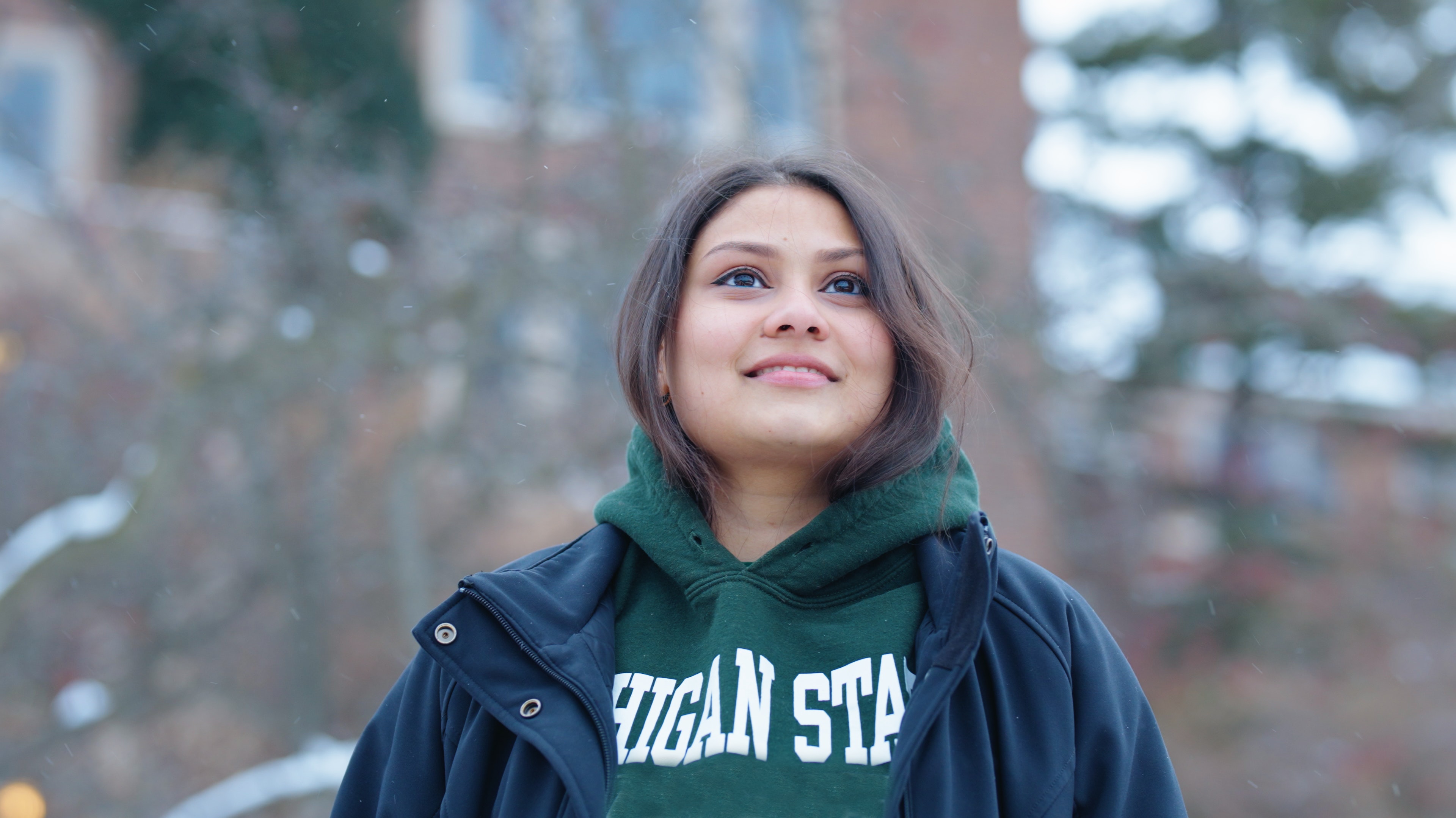 Social Science Scholar Sumaiya Imad wearing an MSU sweatshirt standing outside on campus during the winter.