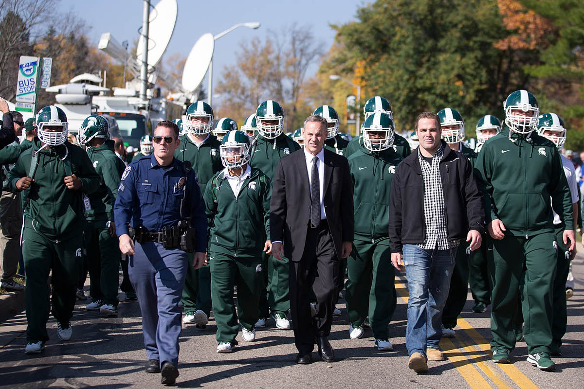 Michigan State Spartans head football coach Mark Dantonio walks with his team to Spartan Stadium on October 25 , 2014 in East Lansing, Michigan.