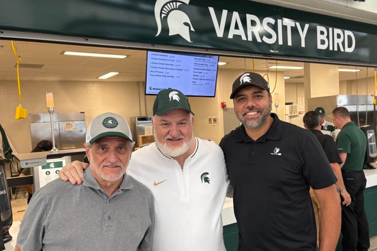 MSU alum Joe Germanotta (left) stands with chefs Art Smith and Hector Guerrero outside the newly opened Varsity Bird concession inside Spartan Stadium.