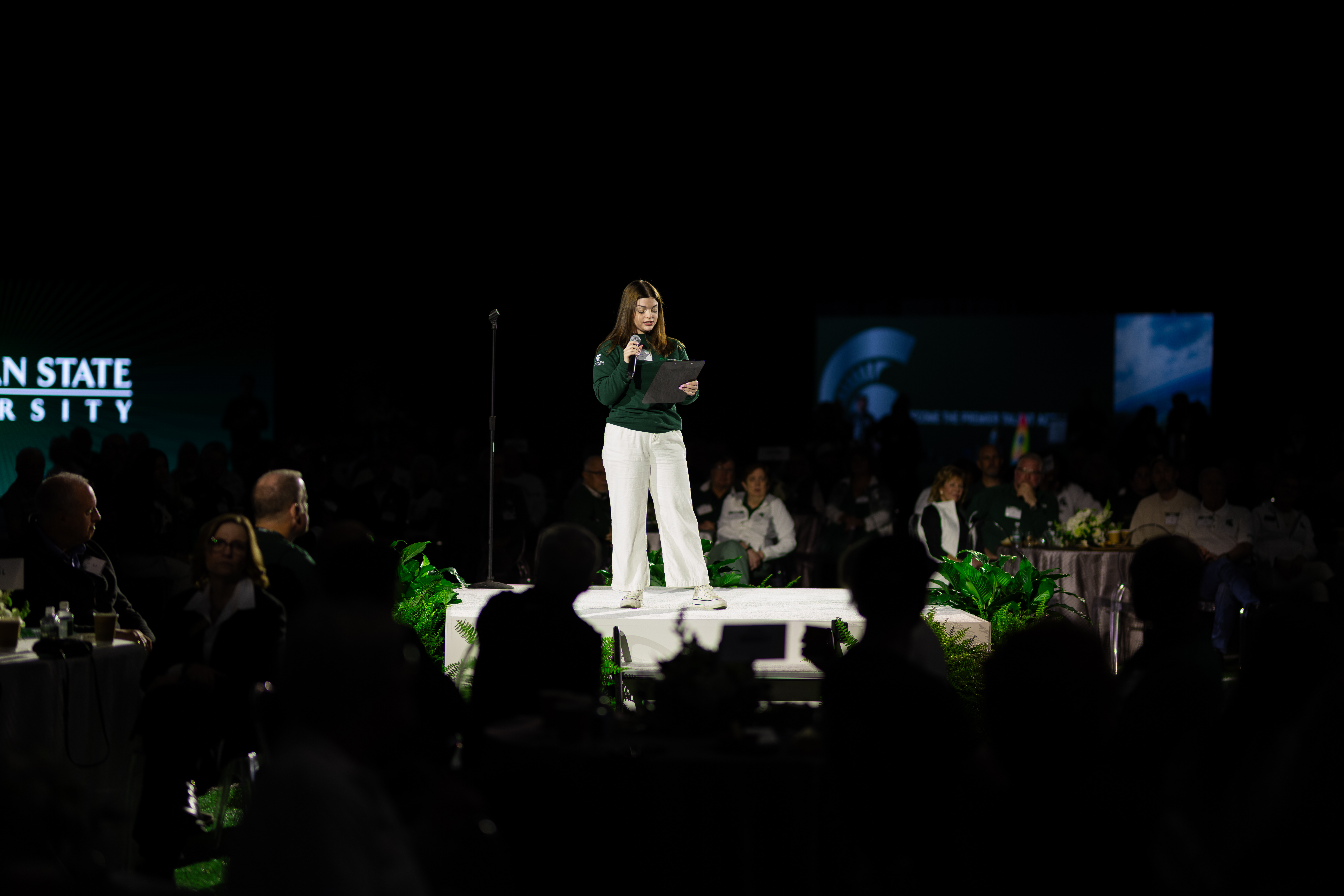 Spartan student Bella Hilden speaking on a circular stage.